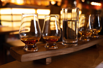 Flight of single malt scotch whisky in glasses served in whiskey bar in Edinburgh, UK