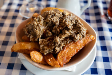 Scottish traditional snack food, hand cut potato chips topped with haggis and gravy