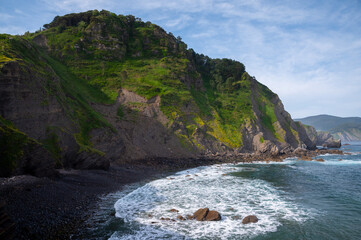 Stone footpath to famous landmark and film location in North of Spain, ocean islet with chapel San...