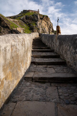 Stone footpath to famous landmark and film location in North of Spain, ocean islet with chapel San...