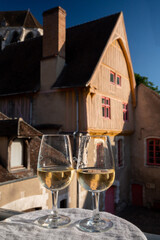 Tasting of white grand cru classe chablis wine with old French houses on background, Burgundy,...