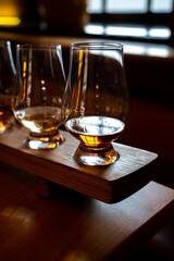 Flight of single malt scotch whisky in glasses served in whiskey bar in Edinburgh, UK