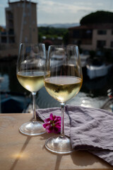 Drinking of cold white wine  with view on yacht harbour of Port Grimaud, summer vacation on French Riviera, France
