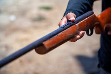 close up of hand holding old gun rifle hunting weapon arms shotgun