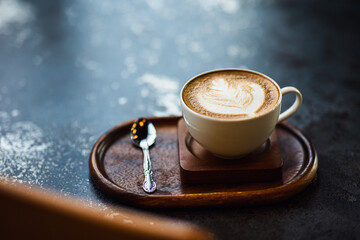 Cup of coffee latte on wood bar in cafe.