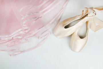 Pointe shoes and a pink tutu on a white background