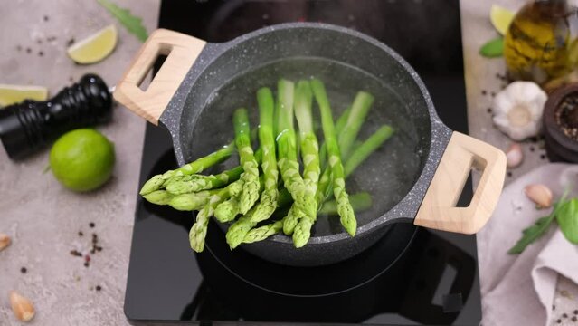 Cooking green asparagus in a pot full of boiling water