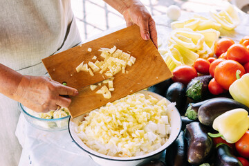 A woman is engaged in the preparation and processing of various fresh farm vegetables