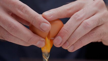 close up of hands breaking egg for cooking cracking