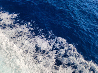 wavy blue sea surface with white foam