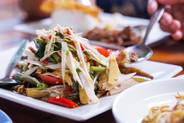 Papaya salad in a white dish is a very popular dish in Thailand.