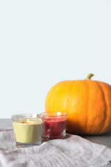 Scandi, minimal style. Cozy autumn still life. Poster design for Halloween or Thanksgiving. Burning candles pumpkin decoration, vertical.