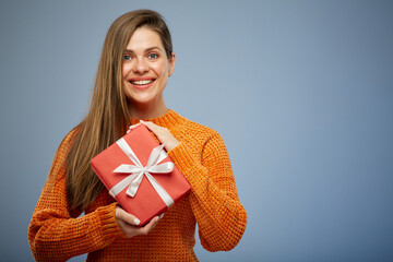 Portrait happy woman with present gift box isolated on blue background.