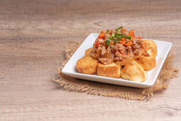 Fried tofu stir fried with ground pork and vegetables in white plate