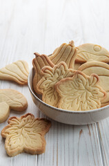 Cookies shaped like pumpkin and leaves on rustic wood background