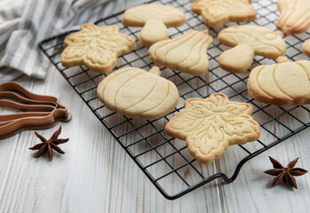 Cookies shaped like pumpkin and leaves on rustic wood background