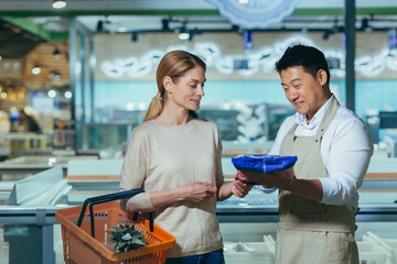 Consultant in a supermarket. A young beautiful woman wants to buy frozen products in the store. An...