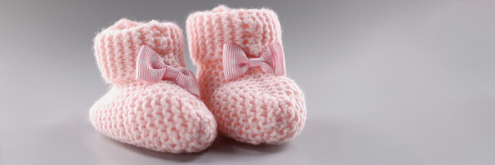 Pair of knitted pink baby booties with cute bow on it