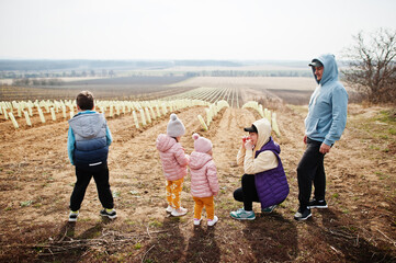 Family stand against vineyard in early spring.