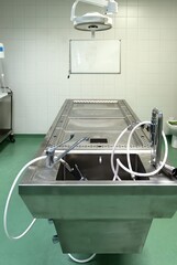 A stainless steel operating table used to perform dissection work in an autopsy