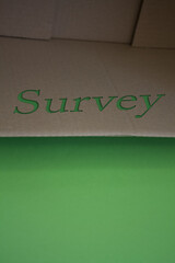 Survey word with cardboard box. Brown folded card box.