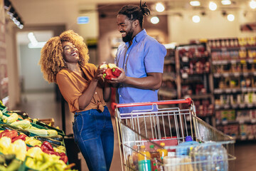 African american couple shopping for healthy fresh food at produce section of supermarket.
