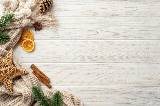 Winter holidays concept. Top view photo of wicker star pine cone spruce branches dried citrus slices anise and cinnamon sticks on white wooden desk background with copyspace