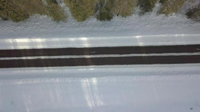 Winter icy road conditiond in Finnish Lapland. White van driving across of image. Straight down shooted stabil aerial footage.