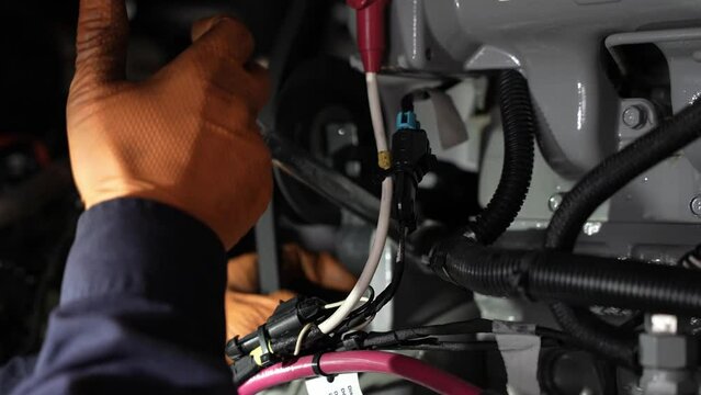 Close Up Of Mechanic In Orange Gloves Working With A Wrench Key On A Refrigerator Trailer Engine At A Truck And Trailer Repair Shop 4k