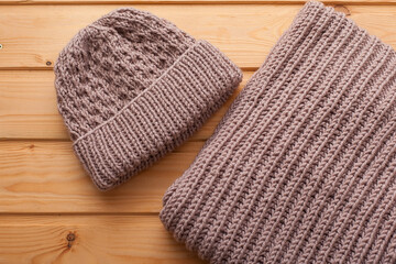 Knitted hat and scarf on grey background.