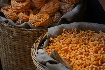 Different varieties of pasta are collected in wicker baskets