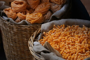Different varieties of pasta are collected in wicker baskets