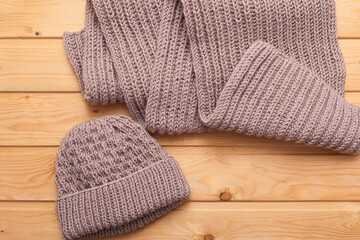Knitted hat and scarf on grey background.
