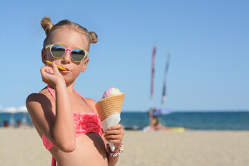 Adorable little girl in swimsuit with delicious ice cream at beach on sunny summer day, space for text - Powered by Adobe