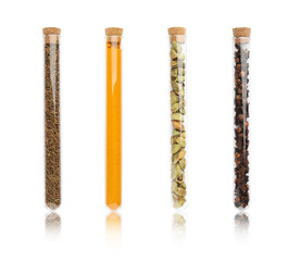Set of glass tubes with different spices on white background