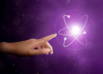 Woman pointing at virtual model of atom on purple background, closeup
