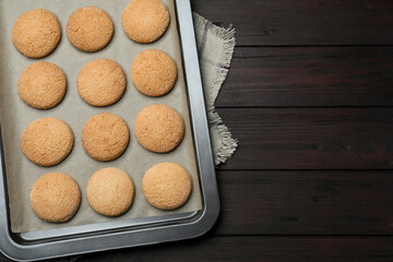 Baking sheet with delicious sugar cookies on wooden table, top view. Space for text