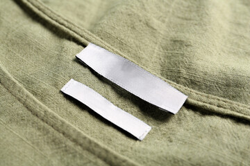 Blank clothing label on green apparel, closeup