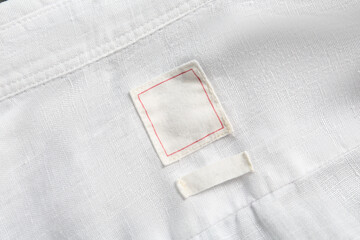 Blank clothing labels on white shirt, top view