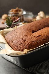 Delicious gingerbread cake in baking dish on grey table, closeup