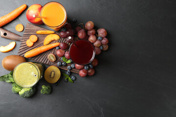 Delicious colorful juices in glasses and fresh ingredients on black table, flat lay. Space for text