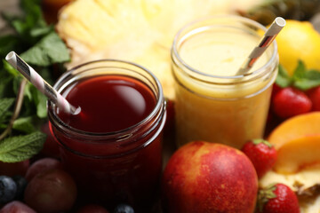 Delicious colorful juices in glasses and fresh ingredients on table, closeup