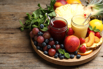 Delicious colorful juices in glasses and fresh ingredients on wooden table