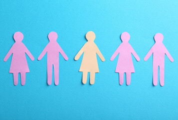 Many different paper human figures on light blue background, flat lay. Diversity and inclusion...