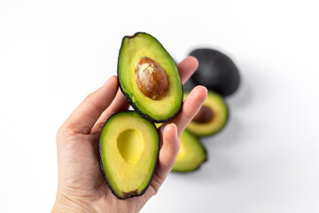 Avocado held in hand. White background.