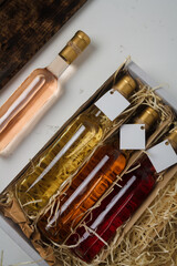 Naklejka premium Assortment of 250 ml bottles of red, pink, white wine in box of wooden shavings, no label. Set of alcohol drinks for present or celebration