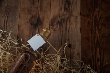 250 ml bottle of pink wine with blank label lying on wooden shavings, wooden table. Alcohol drink....