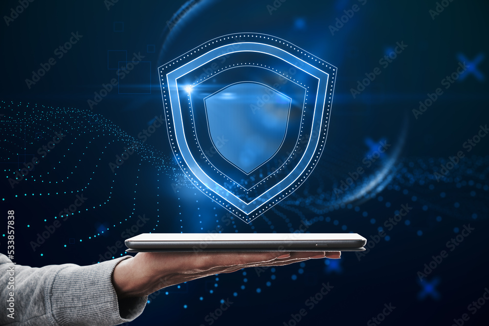 Poster close up of hand holding tablet with creative glowing shield hologram on blue background with variou
