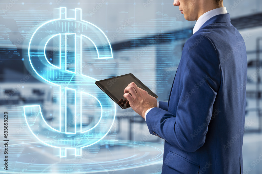 Poster close up of man hand pointing at tablet with glowing dollar and map hologram on blurry office interi