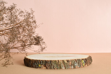 Podium made of natural wood with dried flowers on a beige background. Minimalistic branding scene.